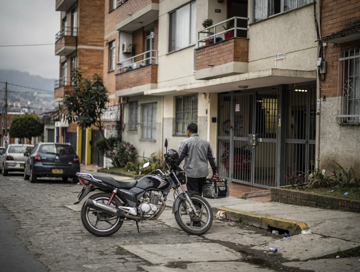 Servicio a domicilio en moto por Bogotá Técnico llegando en moto a un edificio residencial en Bogotá